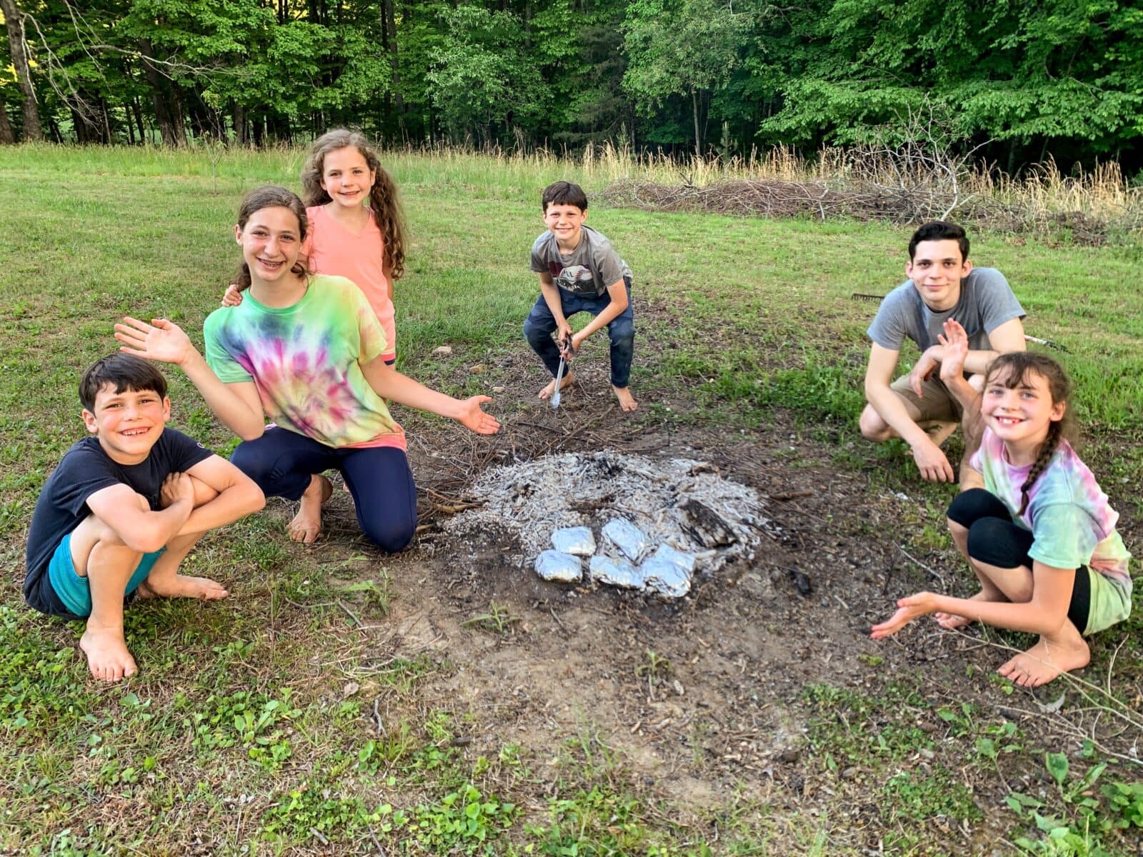 5 kids making foil dinners in the campfire