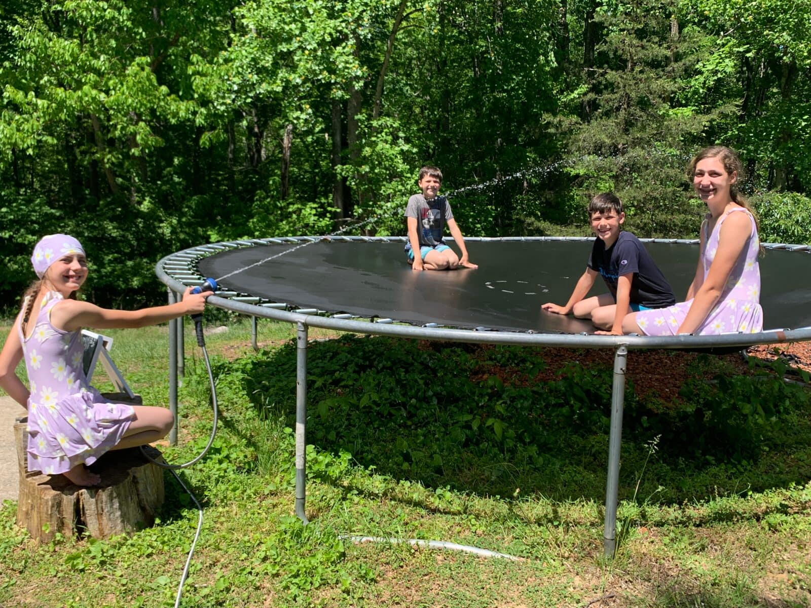 kids playing on the trampoline with a hose