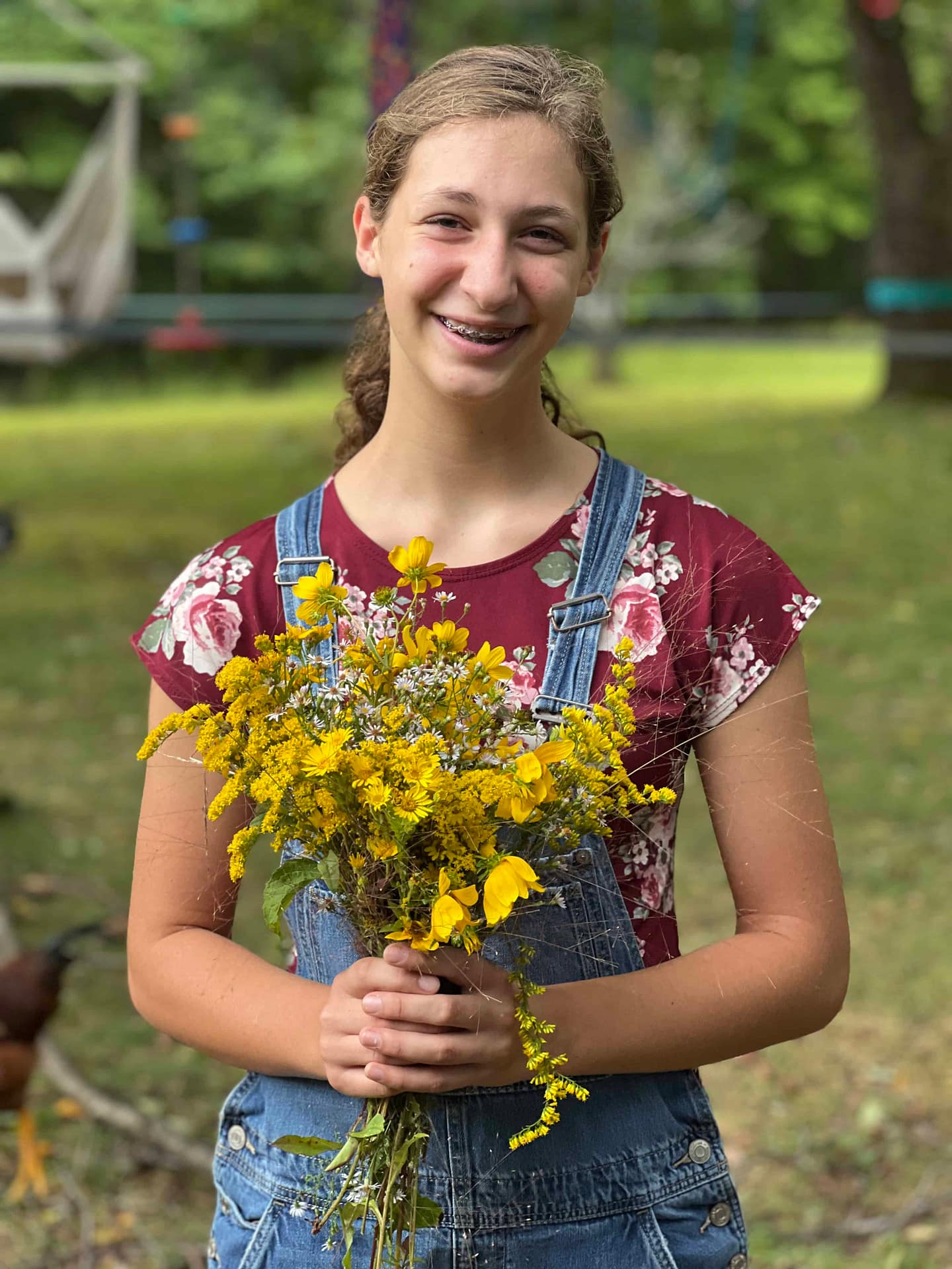 14 year old girl holding wildflowers