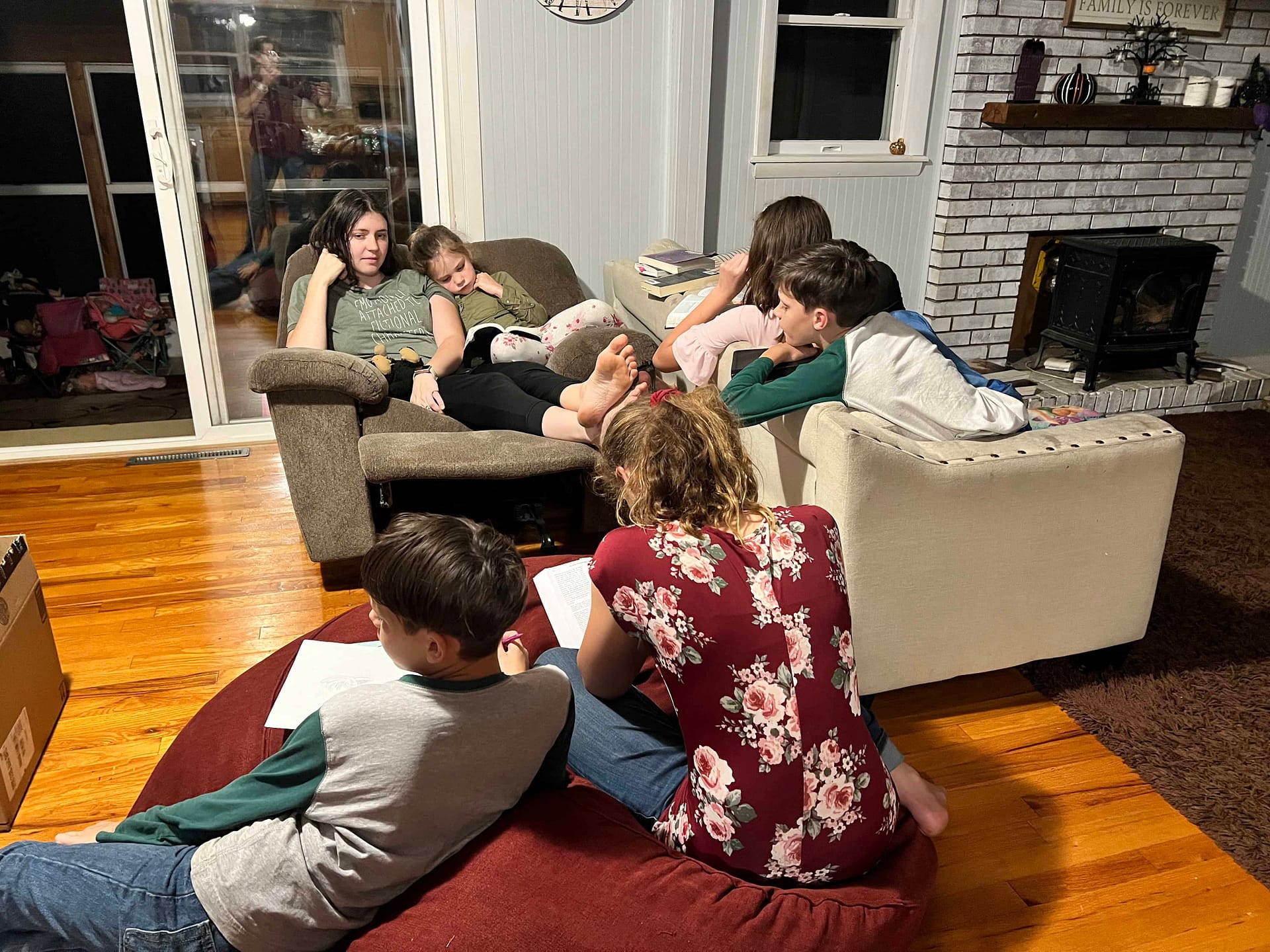 6 kids hanging out around the living room reading scriptures