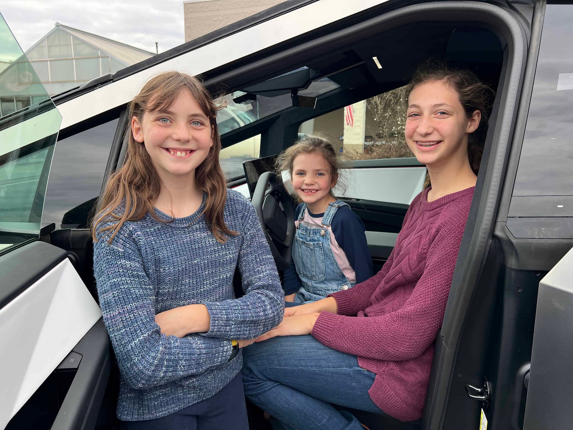 3 girls sitting in a Tesla cybertruck