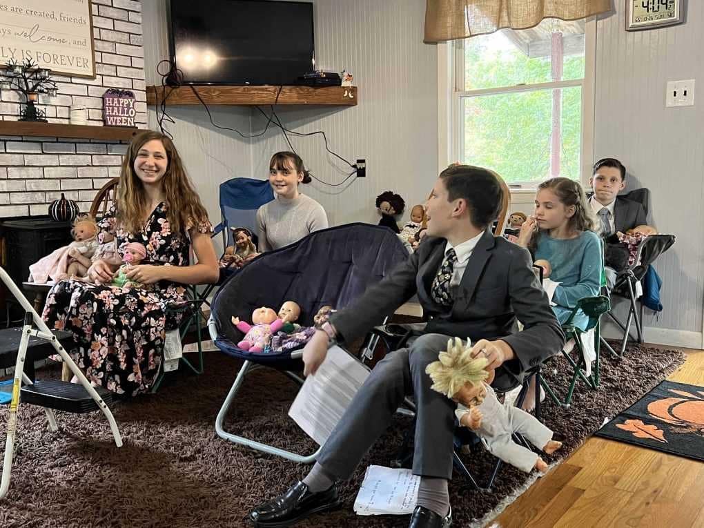 5 kids sitting in chairs in living room